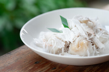 Tradition Thai dessert, Local name Kanom Tom, boiled rice flour dumpling coated with shedded coconut and filled with coconut melted in palm sugar.