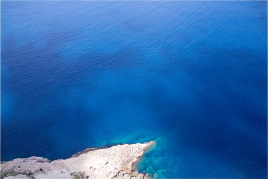 Aerial View of Rocky Peninsula and Vibrant Turquoise Sea