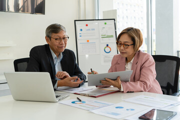 Senior businessmen analyzing data together.