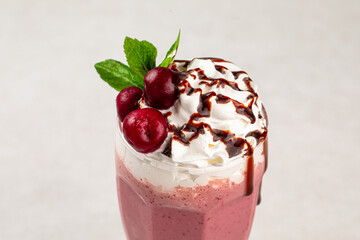 Glass of sweet fresh cherry milkshake with mint