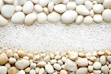 Smooth white stones and foamy water border