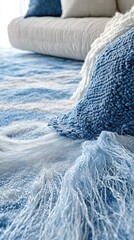 Cozy blue and white textiles on a sofa. Soft, textured throws and pillows