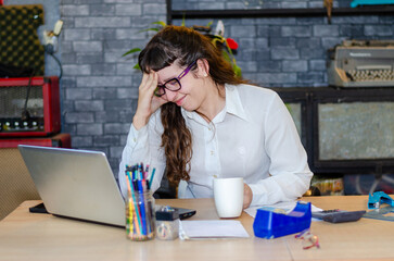 Portrait of tired young business woman work with documents tax laptop computer in office. Sad,...