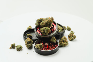 Medical marijuana buds with grinder on white background, close up.