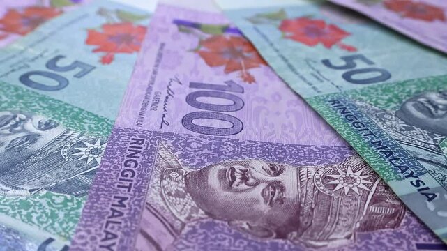 Closeup view of rotating brand new Malaysian ringgit (MYR) banknotes. Concept of saving money for retirement, cash settlement, financial success, literacy and income planning in Malaysia.