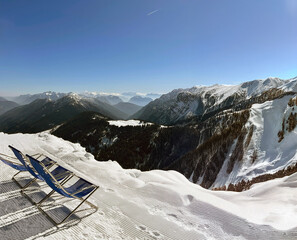 Breathtaking alpine view, complete with lounge chairs nestled in the snowy mountains