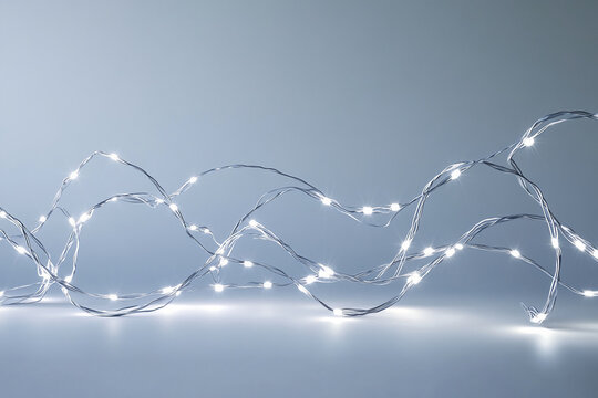 Silver wire string lights on gray background, creating a festive, elegant mood, ideal for holiday or celebration designs, free space for text