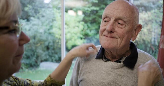 Love, home and woman dressing her husband for an event, work or a romantic date together. Happy, care and loving elderly wife helping her senior man in retirement while getting ready at their house.