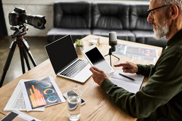 Individual engaged in digital content creation, utilizing multiple devices on a wooden workspace