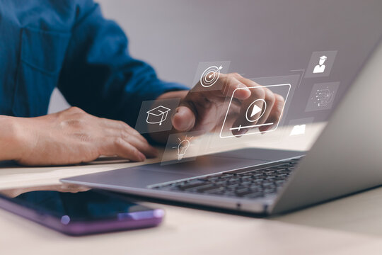 Concept of online education or distance learning with wireless internet technology, male student using hand to touch on virtual computer screen, learning or studying according to university course