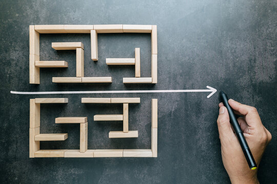 A hand that draws a straight line through a maze game with the shortest possible line, shorten the process, and simplify concept