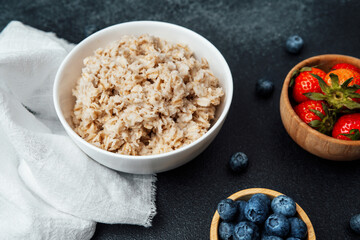 Healthy oatmeal served with fresh blueberries and strawberries in a bowl