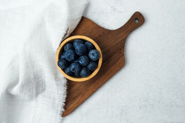 Fresh blueberries arranged in a wooden bowl on a countertop