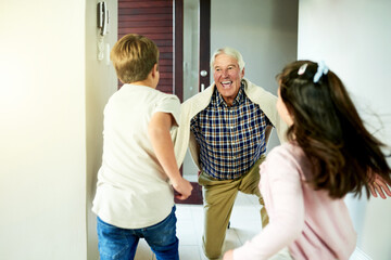 Fototapeta premium Children, running and happy for grandfather visit in home with arrival greeting, hello and reunion welcome. People, family connection and support by front door with bonding together and relationship