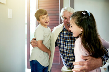 Fototapeta premium Children, smile and hug grandfather for welcome in home with weekend visit, greeting and reunion. Excited people, family connection and hello by front door with bonding together and happy arrival