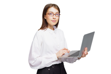 Young professional woman engaged in typing on a laptop while standing, showcasing focus and elegance