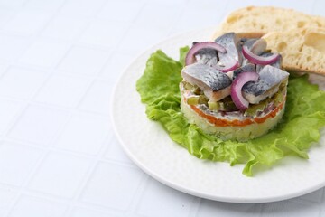 Delicious salad with herring, vegetables and bread on white tiled table, closeup. Space for text