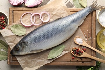 Salted herring and spices on light grey table, flat lay