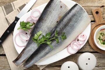 Tasty herring fillets with spices on wooden table, flat lay