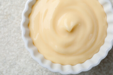 Tasty vanilla pudding on light textured table, top view
