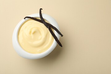 Tasty vanilla pudding with pods on beige background, top view. Space for text