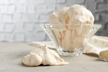Delicious homemade meringue cookies in bowl on gray table