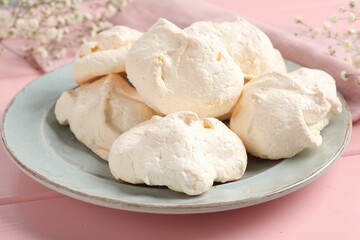 Delicious homemade meringue cookies on pink wooden table, closeup