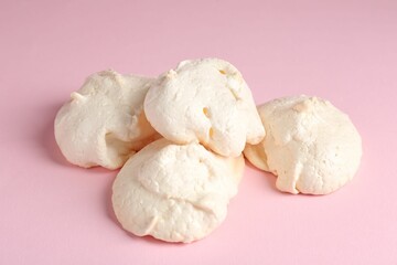 Delicious homemade meringue cookies on pink background