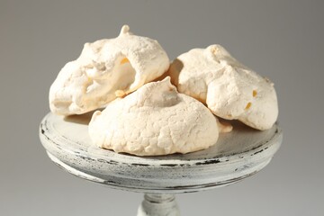 Delicious homemade meringue cookies on gray background, closeup