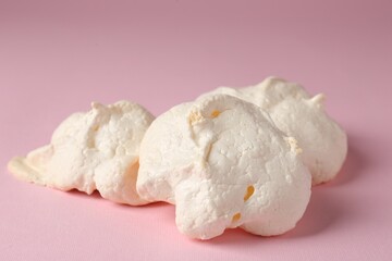 Delicious homemade meringue cookies on pink background, closeup