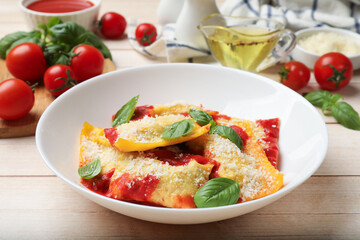 Delicious ravioli with tomato sauce, parmesan cheese and basil on white wooden table, closeup