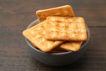 Tasty salty crackers on wooden table, closeup