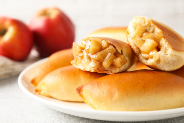 Tasty baked patties with apples on light grey table, closeup