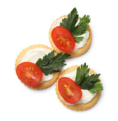 Tasty crackers with cream cheese, tomatoes and parsley isolated on white, top view