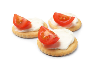 Tasty crackers with cream cheese and tomatoes isolated on white
