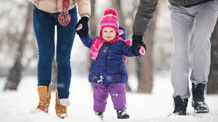 Young family with baby girl outdoors having fun in the snow. Shallow DOF. Developed from RAW;...