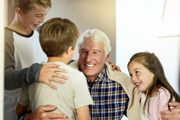Hug, love or smile with grandpa and kids in home together for bonding, relationship or visit. Family, happy and retirement with senior man talking to grandchildren in apartment or development