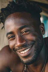 Obraz premium A close-up portrait of a smiling black man, radiating warmth and positive energy.