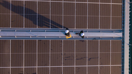 Aerial view of engineers inspecting rooftop solar panels