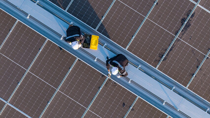 Aerial view of engineers inspecting rooftop solar panels