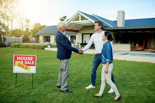 Property, realtor handshake and homeowner couple with sold sign, deal and new house for milestone together. Agreement, mortgage and investment with man, woman and purchase for home ownership success