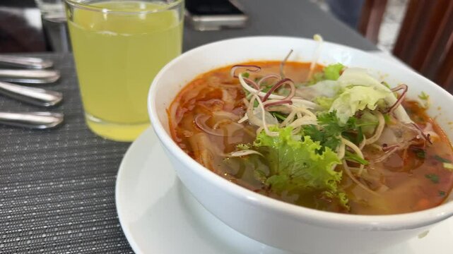 soup with lettuce leaves in a white plate asian cuisine with bean paste and pineapple juice in a glass. High quality 4k footage