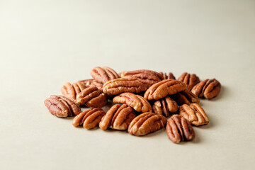 Delicious pecan nuts scattered on a neutral background ready for snacking