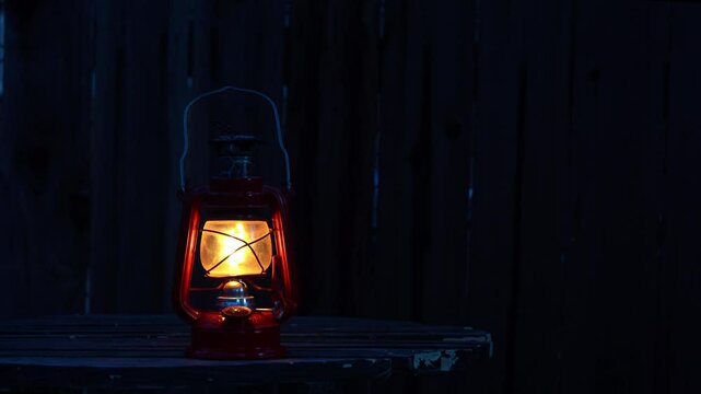 The flickering flame of a kerosine lamp at dusk