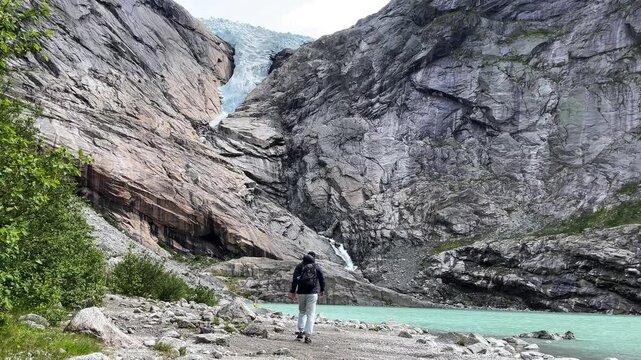 Man among mountains and glaciersv Briksdalsbreen