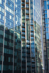Fototapeta premium Urban scene featuring contemporary high rise buildings with glass facades, balconies, and reflections. Likely located in London, no landmarks visible.