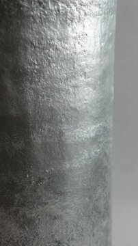 Abstract shiny metal texture with rough surface, reflective silver pattern, cool industrial design, background with detailed grainy appearance