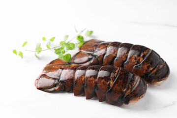 Raw lobster tails and microgreens on white marble table, closeup