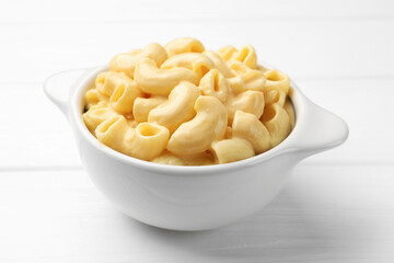 Delicious macaroni and cheese on white wooden table, closeup