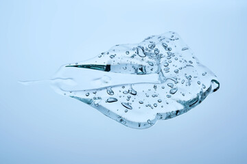 The texture of a cosmetic gel with bubbles on a blue background.